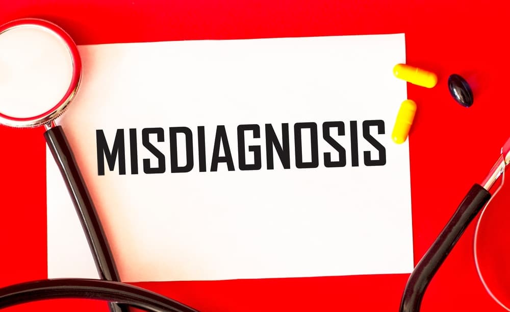 On a red background, pills, a stethoscope and a notepad with the inscription.